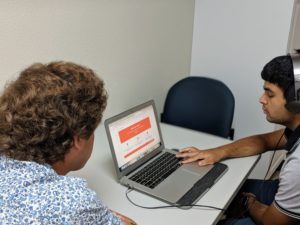 Young man learning how to use a screen reader on a laptop
